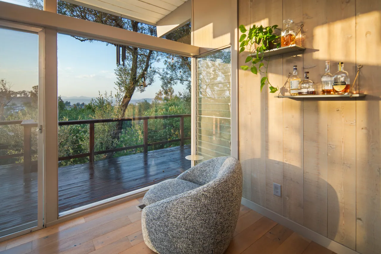 A corner of the great room where two glass walls meet, with floating shelves