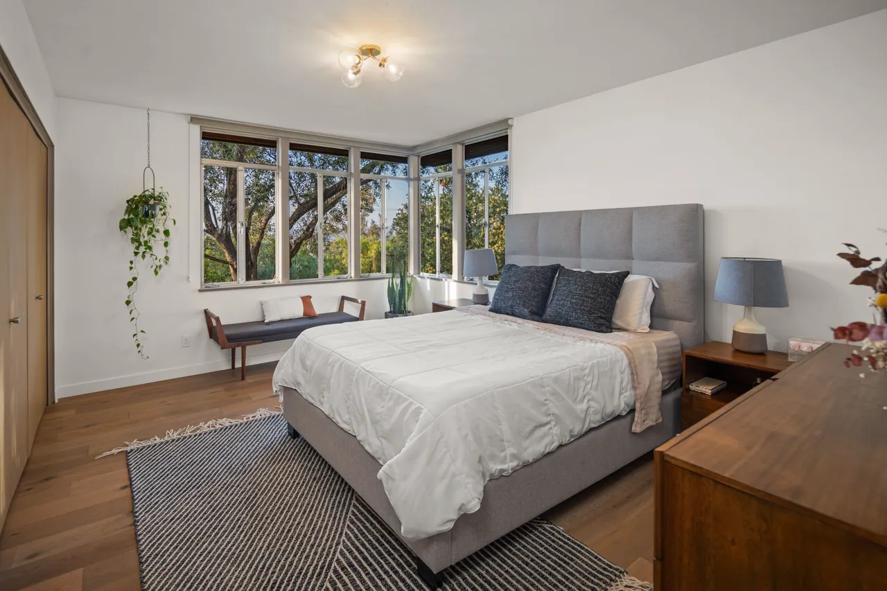 Primary bedroom with corner windows to the trees