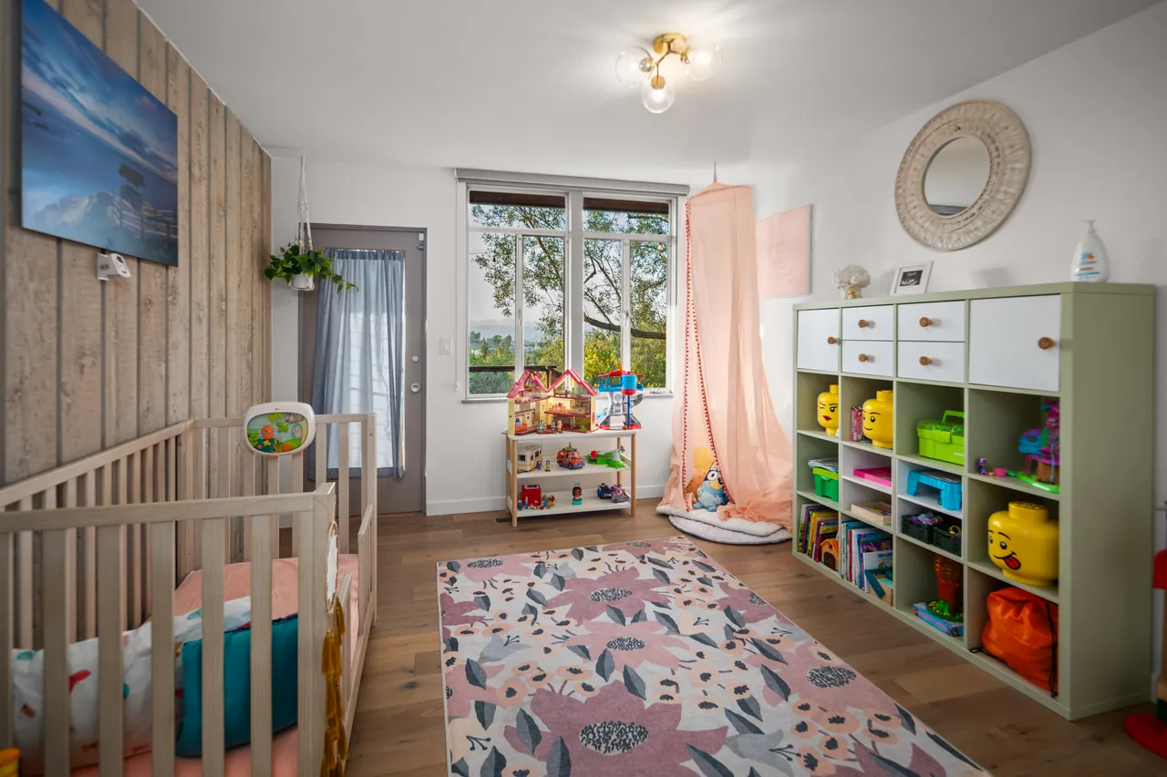 Second bedroom with a wood-paneled wall and built-in storage