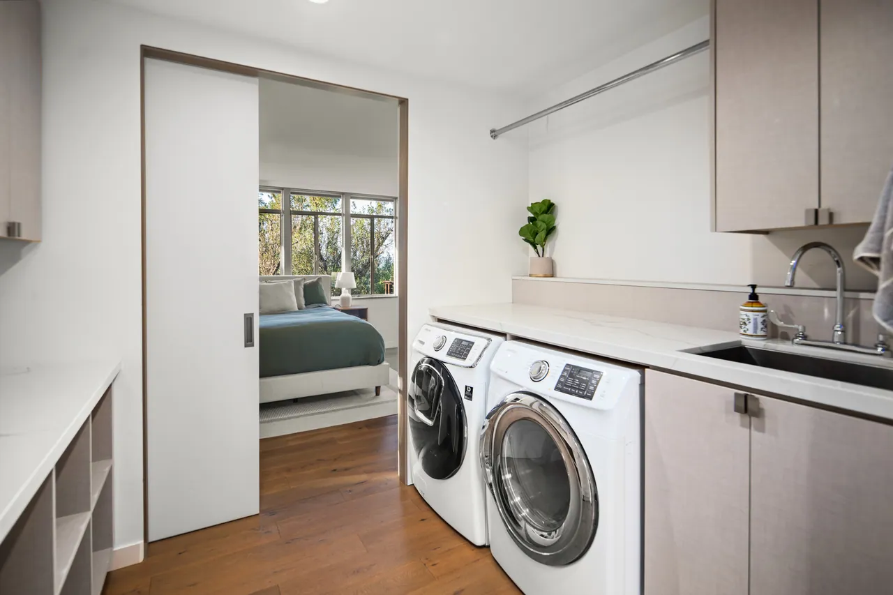 Laundry room with washer, dryer, sink and cabinetry