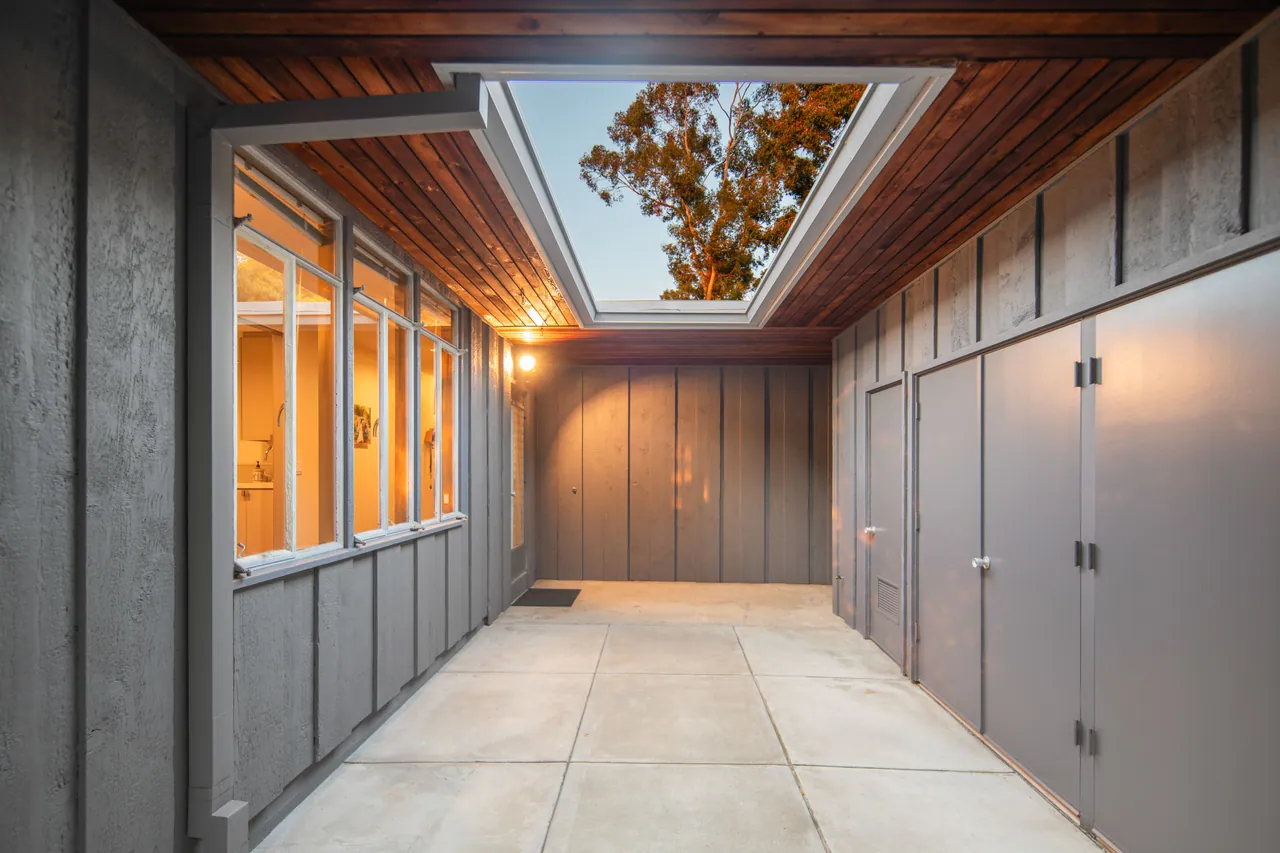 Open-sky breezeway with a redwood ceiling and skylight cutout