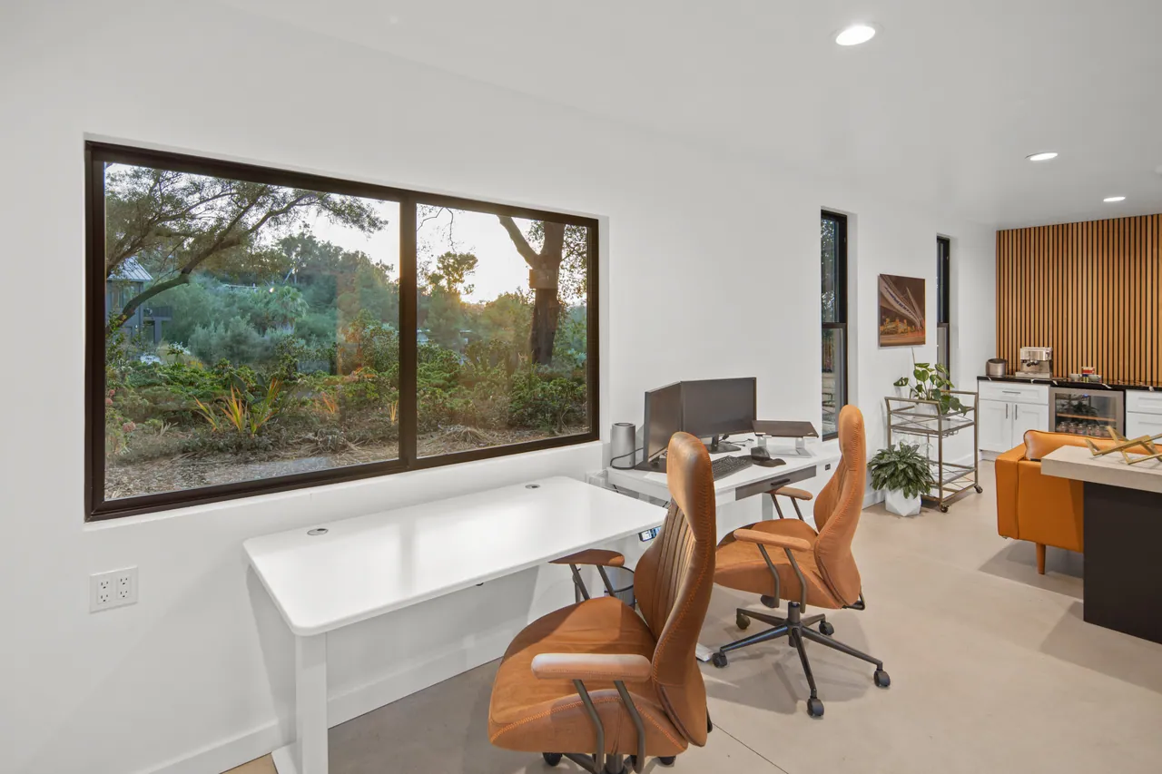 Office addition desk beneath a picture window to the hillside