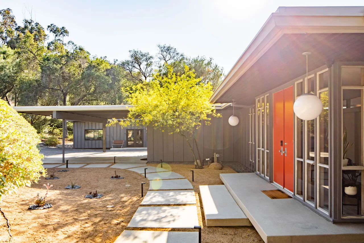 Entry court with the carport beyond and a palo verde in bloom